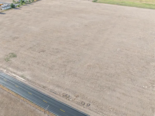 Expansive vacant lot featuring a paved road frontage