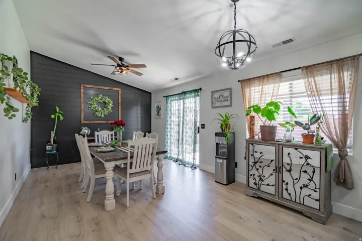 Open-concept dining and living area featuring light wood-finish flooring, recessed ceiling lighting, and a ceiling fan