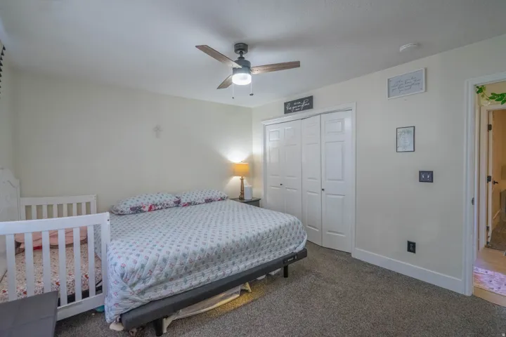 Recessed lighting, ceiling fan with light fixture, neutral carpeting, white bi-fold closet doors, and white trim
