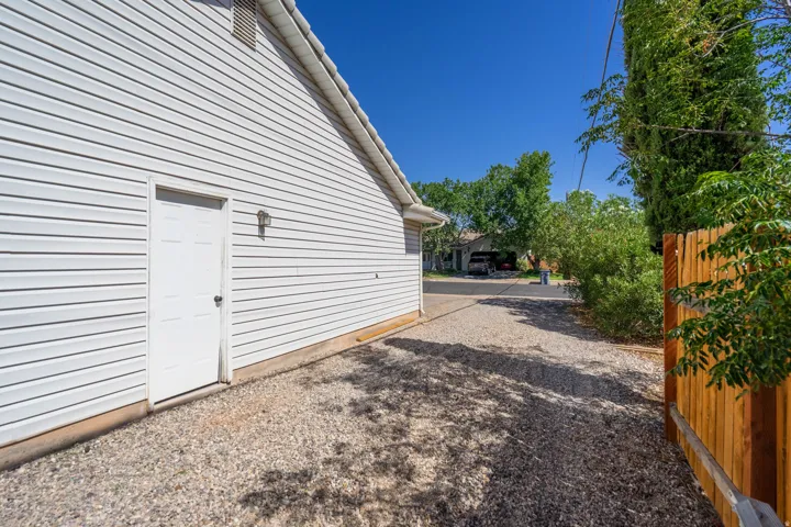 Gravel driveway with direct access to detached garage featuring a white overhead door