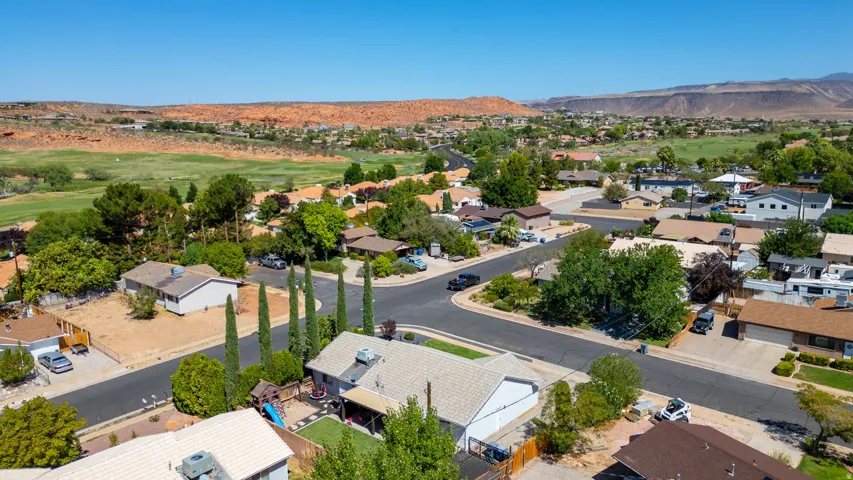 Aerial view of a residential community nestled in a fertile valley with mature landscaping throughout the neighborhood