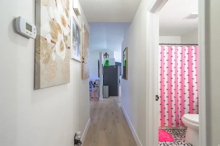 Hallway featuring light wood-finish flooring, white walls, and a recessed ceiling light