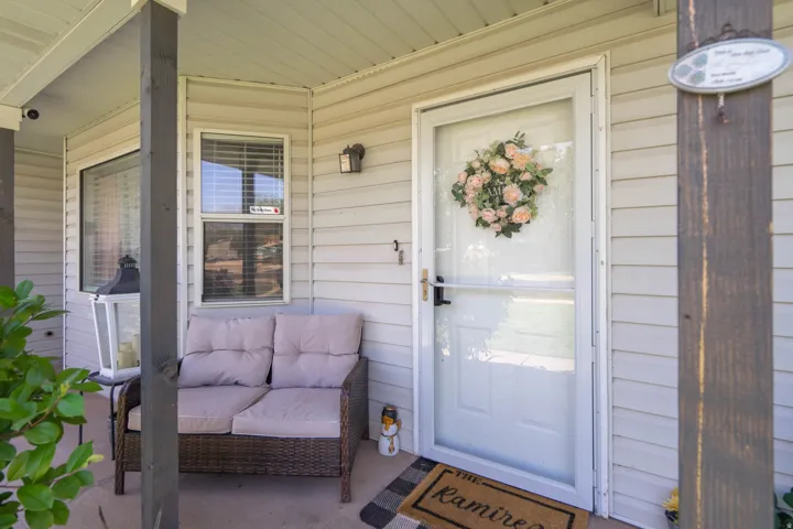 Inviting covered porch with durable siding and a white entry door
