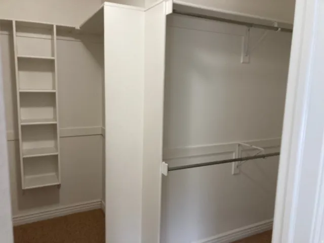 Built-in shelving, two hanging rods, and an overhead shelf optimize closet organization