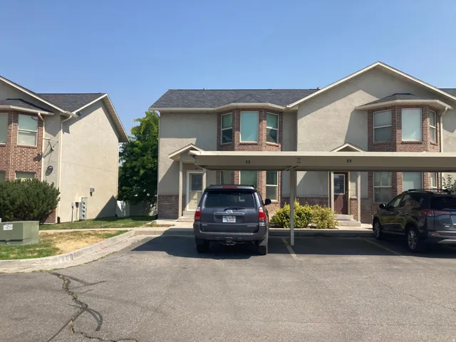 Exterior featuring brick accents, bay windows, and covered parking