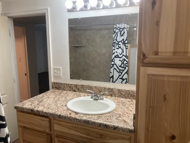 Vanity with an integrated sink, laminate countertop, and wood-finish cabinetry