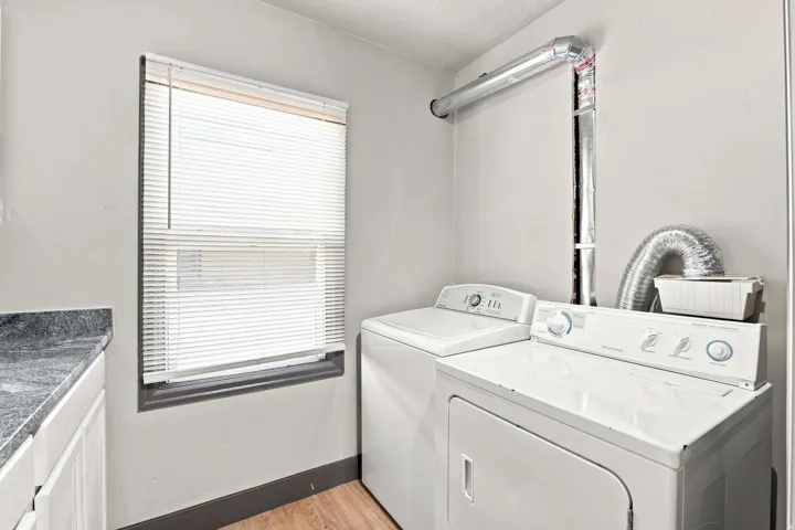 Laundry area featuring a window, built-in countertop, and wood-finish flooring