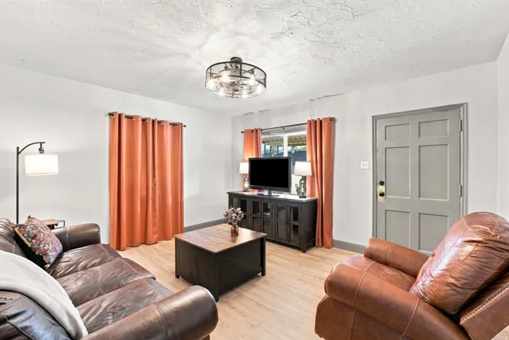 Light-toned wood-finish flooring complements the neutral wall color