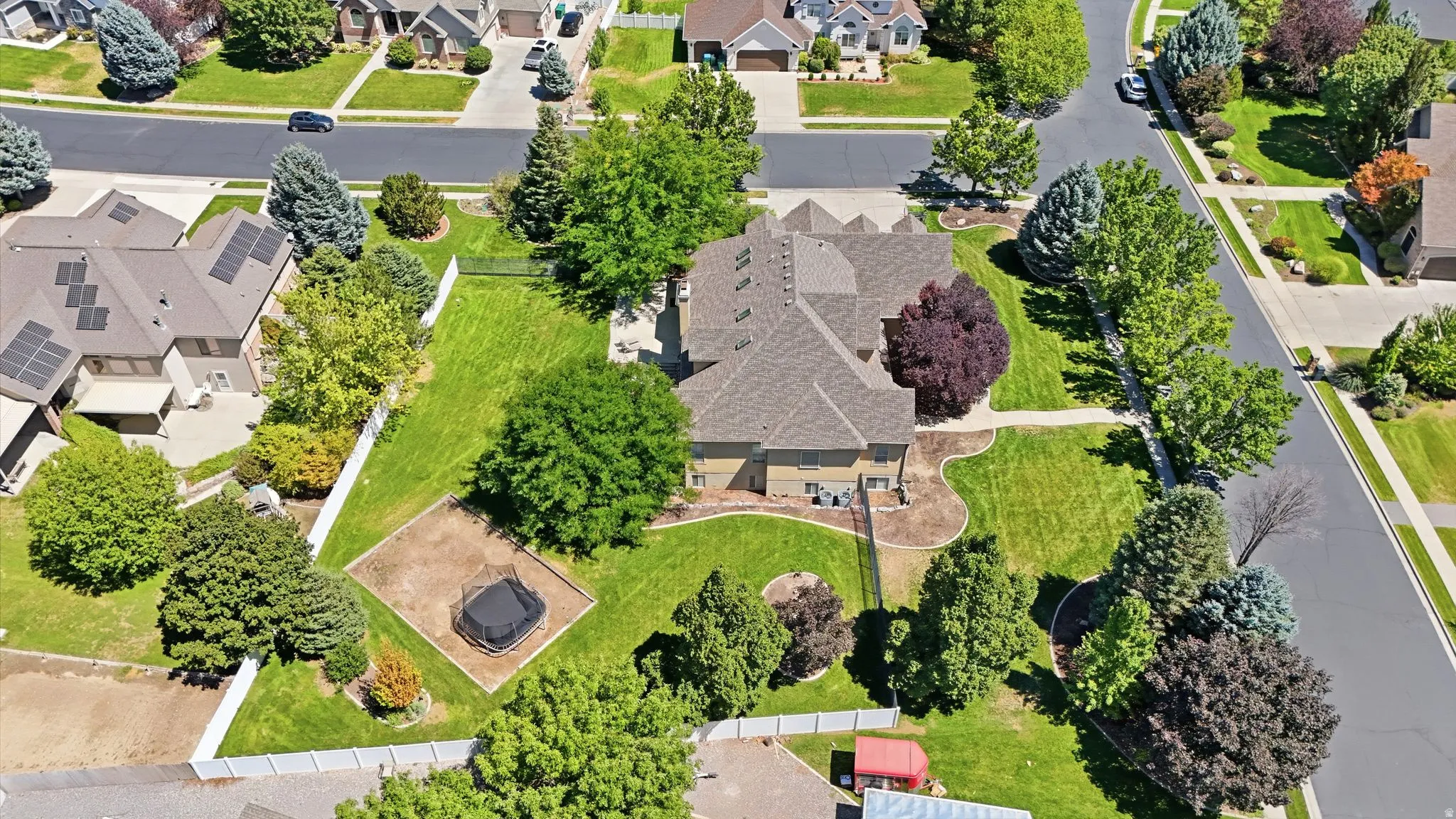 Expansive green lawn with mature trees and paved pathways
