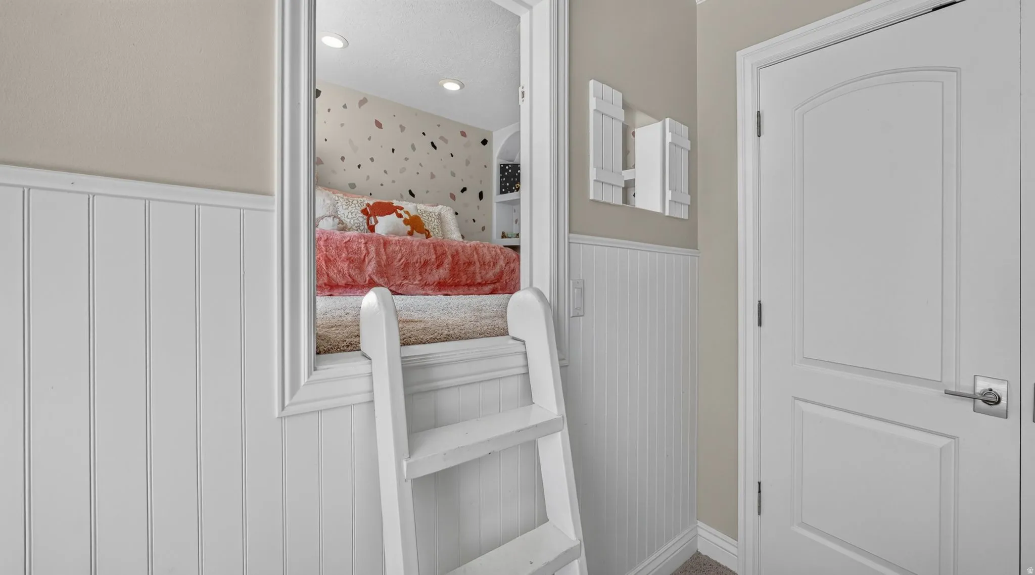Built-in ladder with a lofted bed, recessed lighting, and built-in shelving