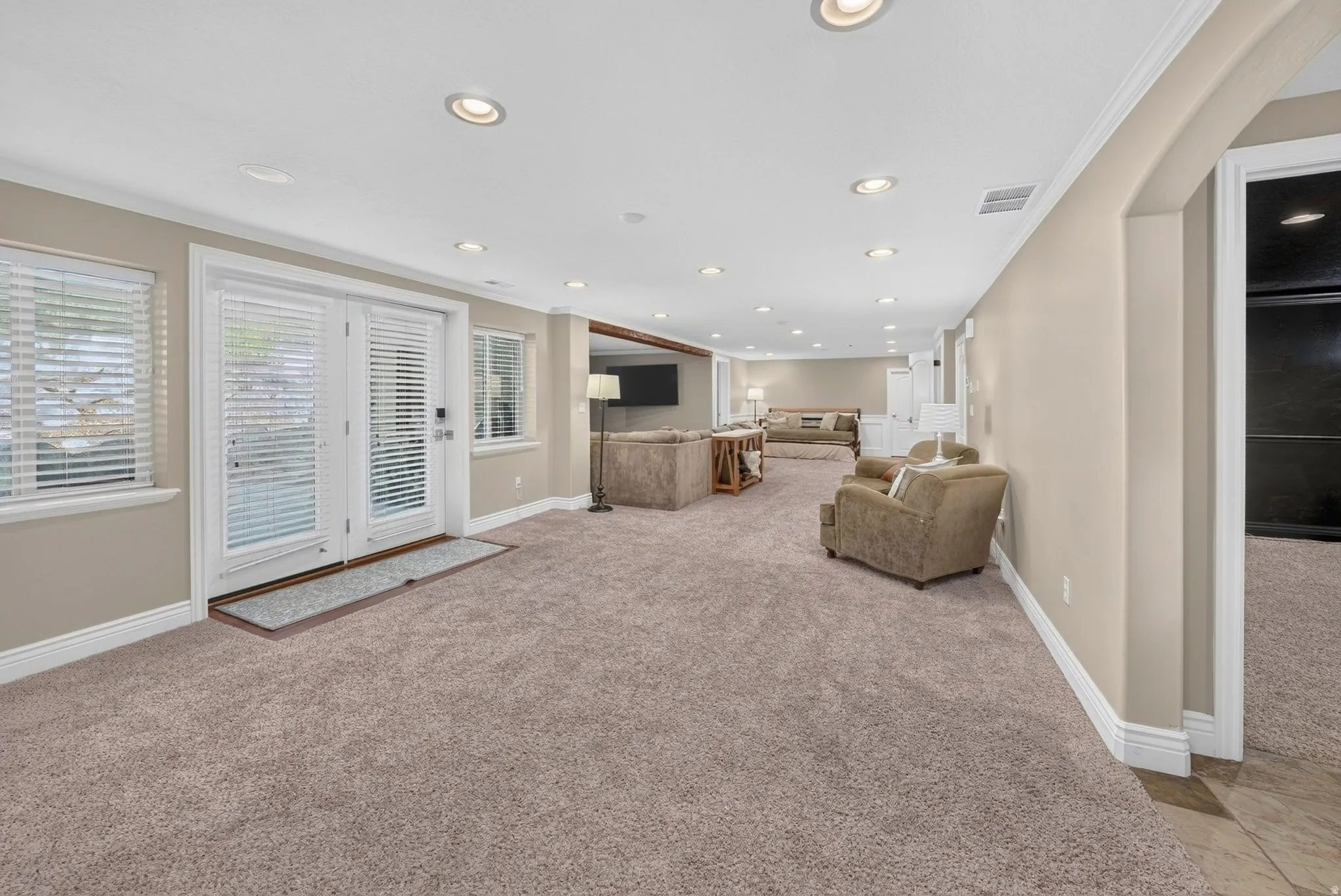 Spacious room featuring neutral carpeting, recessed lighting, and white trim