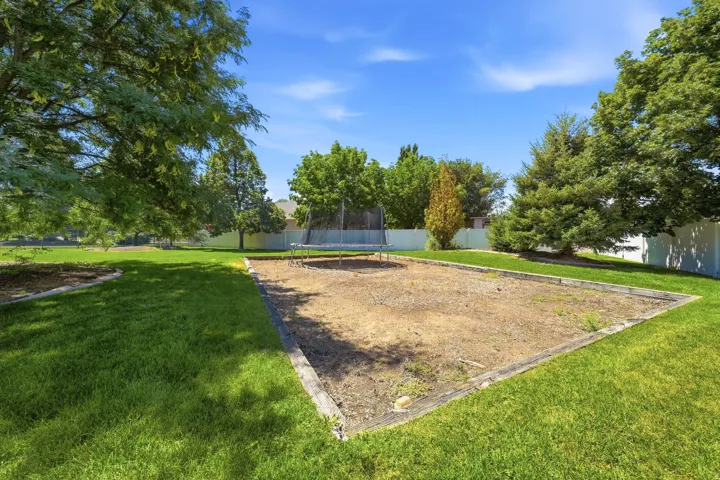 Expansive green space featuring a large lawn area and mature trees