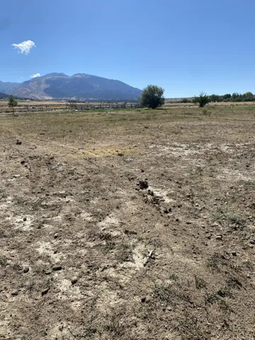 Expansive open lot with a stunning mountain backdrop looking toward the fenced bull pen.