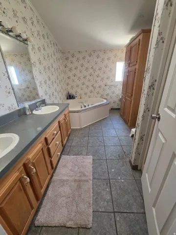 Dual vanity with built-in soaking tub, and tile flooring