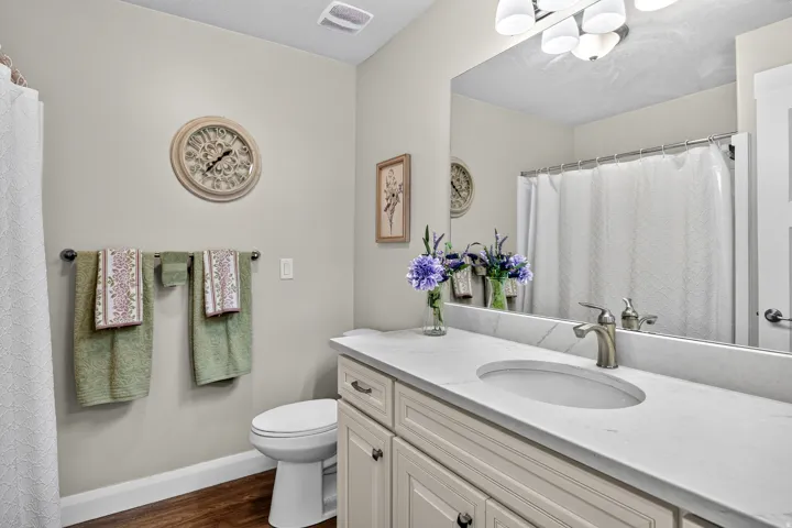 White vanity with shaker-style cabinetry, an integrated sink, and a light-toned countertop
