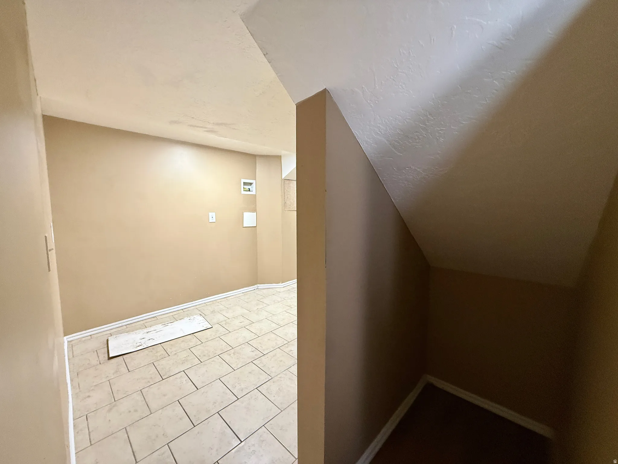 Tiled flooring in a utility area with appliance hookups