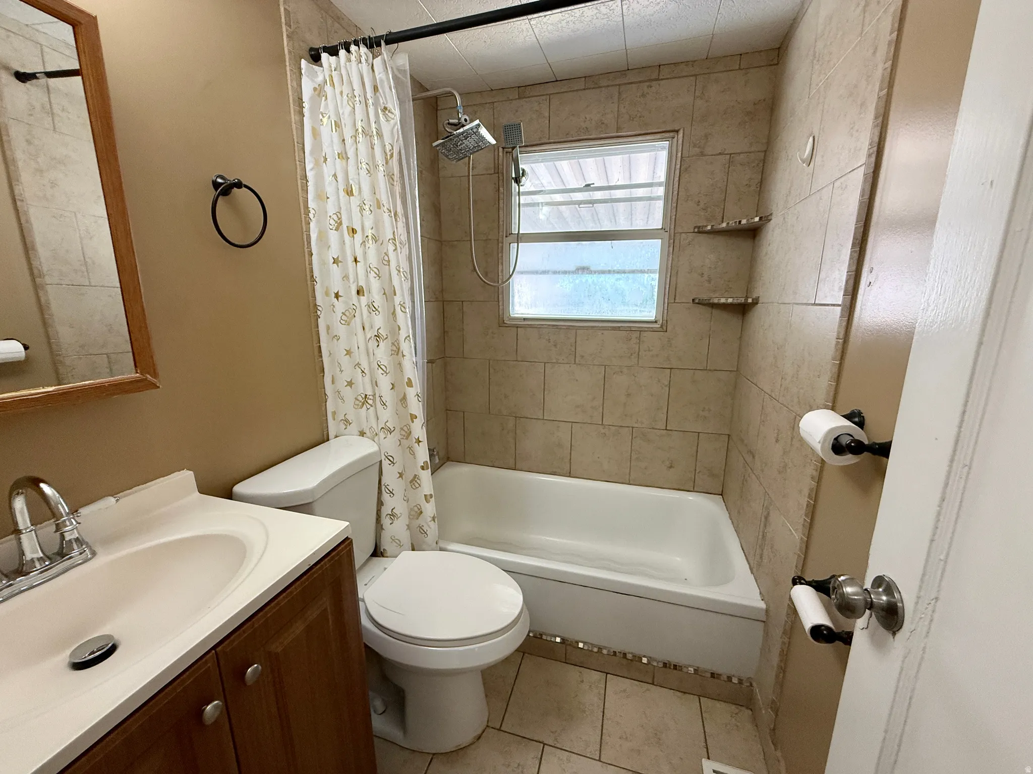 Tiled bathtub surround with built-in corner shelves and a rain shower head