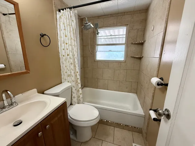 Tiled bathtub surround with built-in corner shelves and a rain shower head