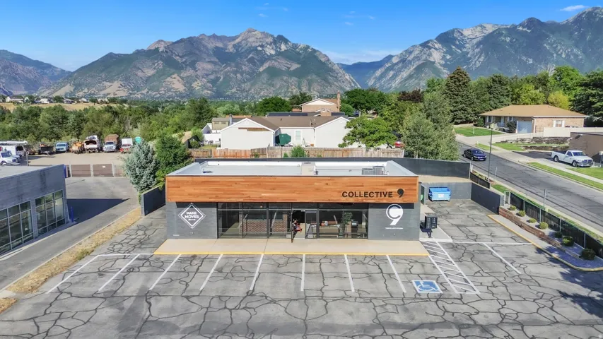 Modern commercial building with a wood-finish facade, expansive storefront windows, and dedicated on-site parking