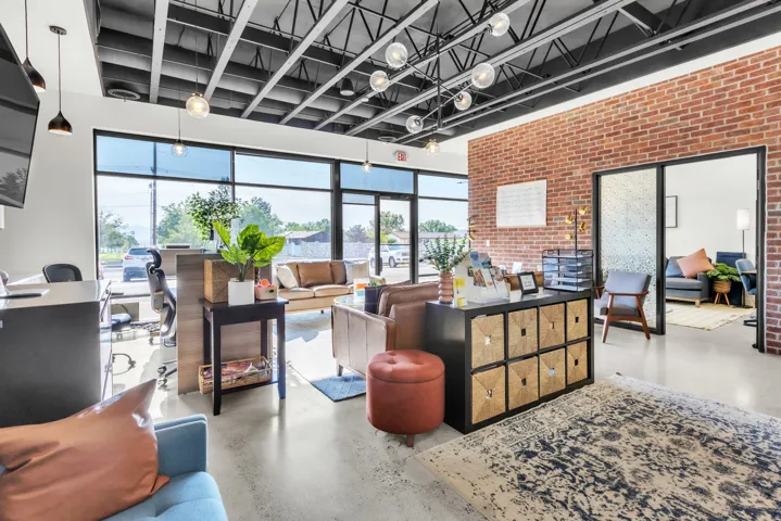 Exposed brick accent wall and a dark exposed ceiling
