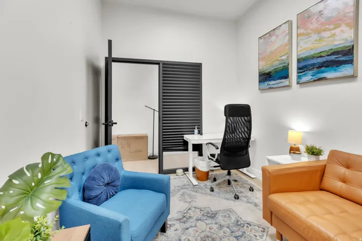 White walls, wood-finish flooring, recessed lighting, and a black louvered door