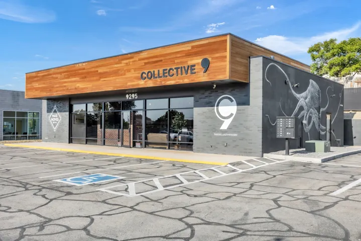 Modern commercial building featuring a wood-finish facade, expansive glass storefront, and an integrated mural