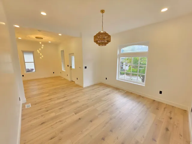 Recessed lighting, wood-finish flooring, and a decorative ceiling fixture