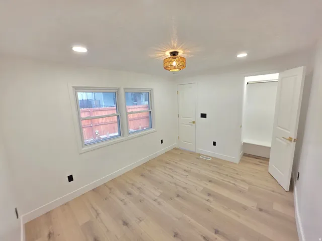 Light wood-finish flooring, recessed lighting, and a modern ceiling fixture