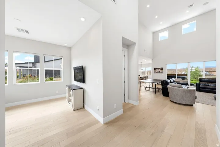 Hardwood-style flooring throughout, high ceilings, recessed lighting, and multiple windows