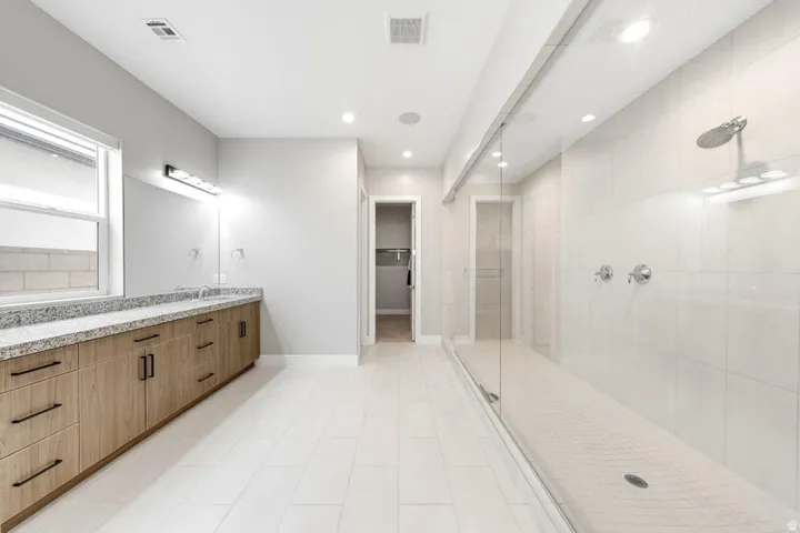 Dual vanity with stone countertop and wood-finish cabinetry