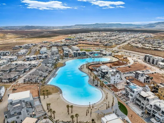 Expansive community featuring a large, clear water lagoon, surrounding residential properties, and distant mountain scenery