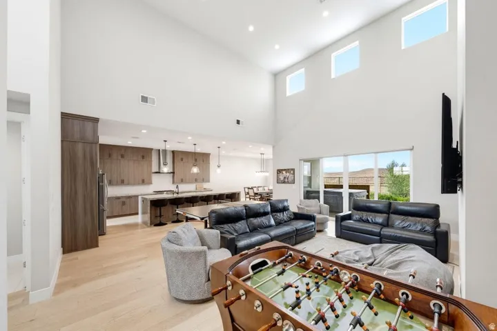 Vaulted ceilings, large windows, wood-finish flooring, full kitchen with island seating, and glass sliding doors