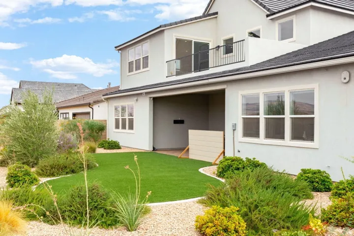 Modern exterior with light stucco finish and black tile roof