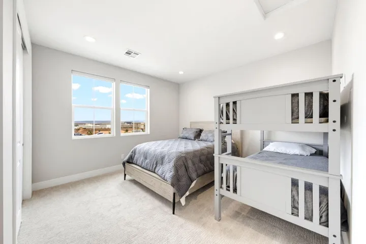 Recessed lighting, plush carpeting, light-toned walls, and multiple windows