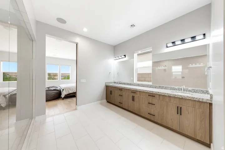 Dual vanity with wood-finish cabinetry and stone countertops