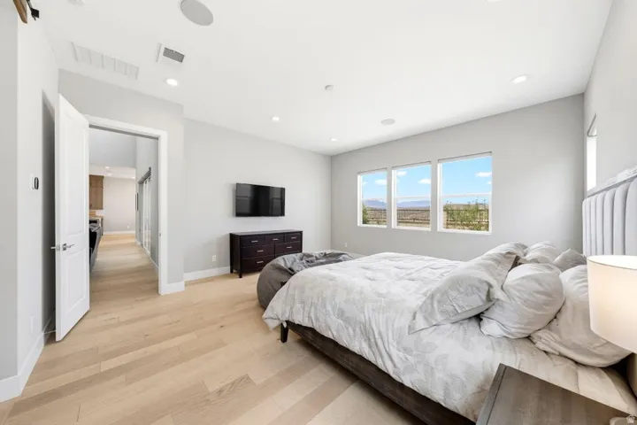 Light wood-finish flooring, recessed lighting, and multiple windows with exterior scenery
