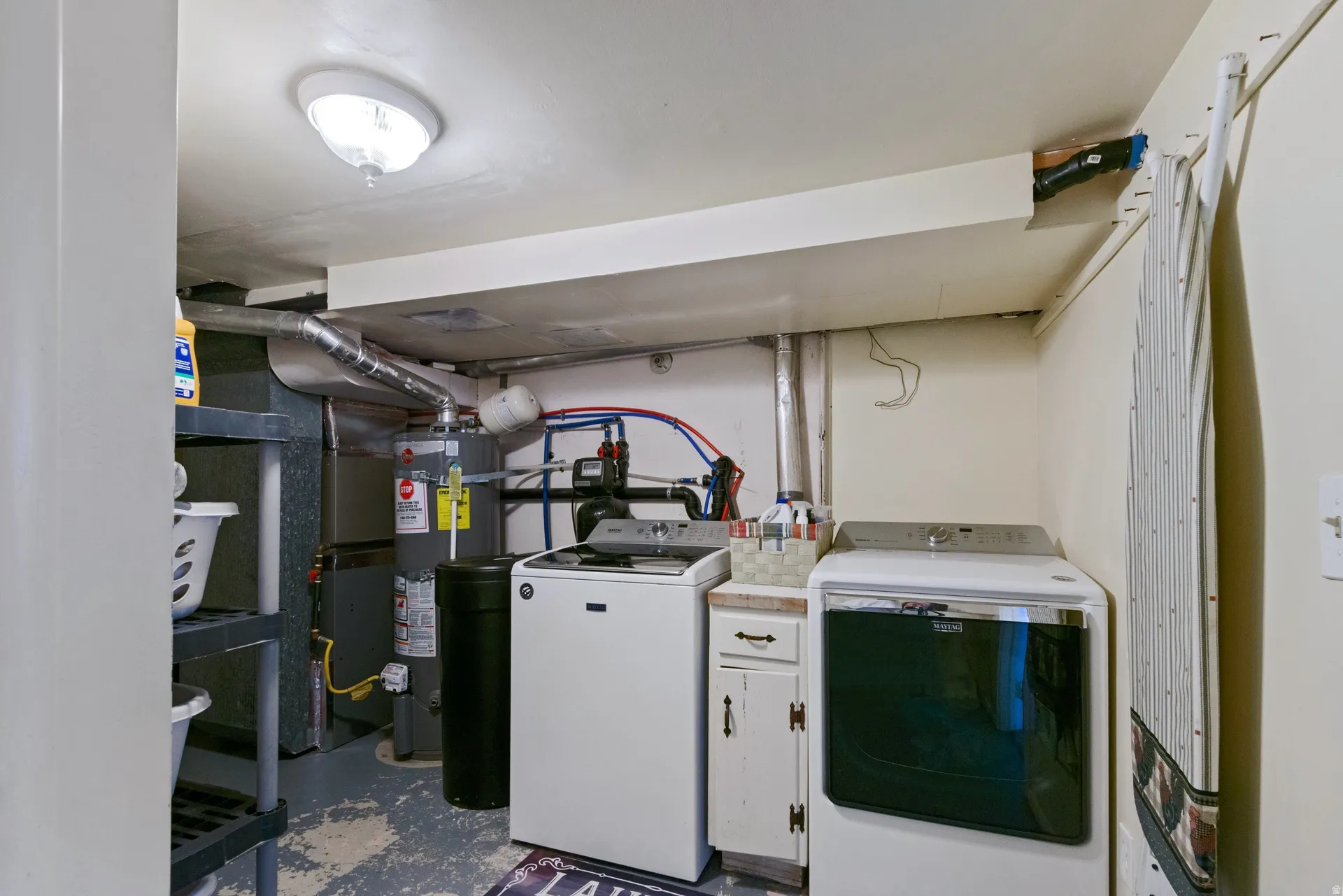 Utility space featuring a water heater, furnace, and built-in cabinetry with a countertop