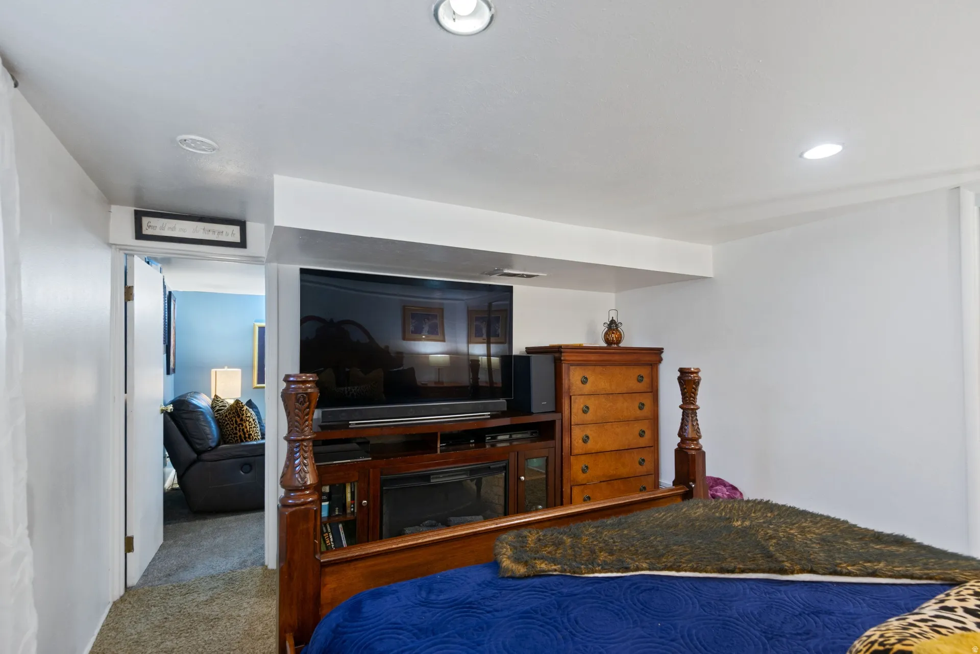 Recessed lighting, white walls, and a television media console with an integrated electric fireplace
