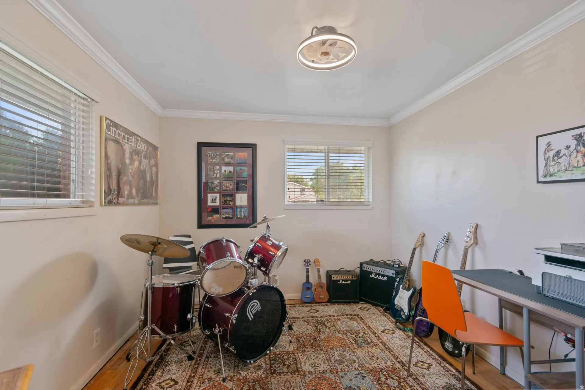 Crown molding, dual windows with blinds, wood-finish flooring, and a flush-mount ceiling light