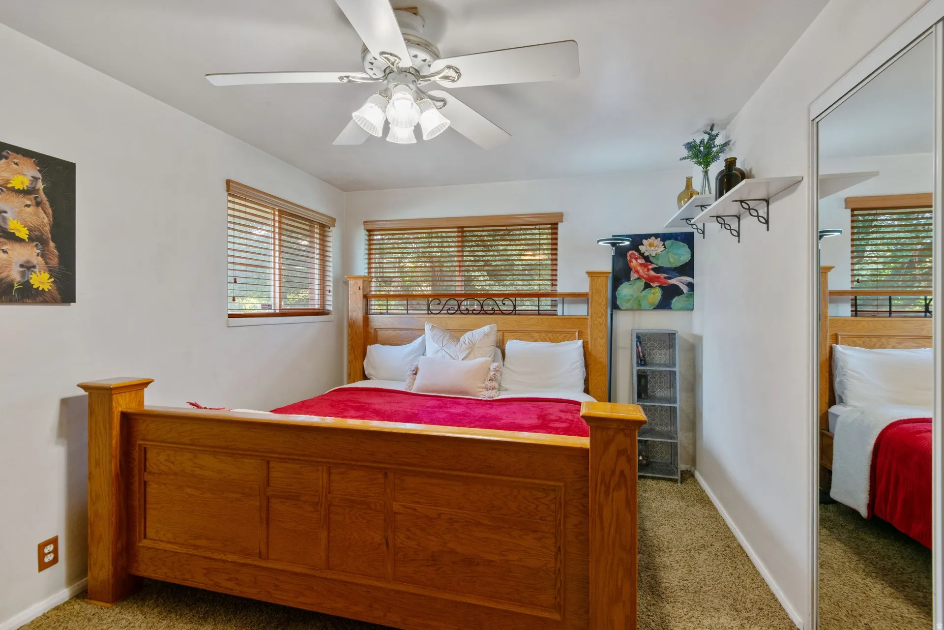 Room featuring two windows with wood blinds, a ceiling fan with integrated lighting, and a mirrored closet door