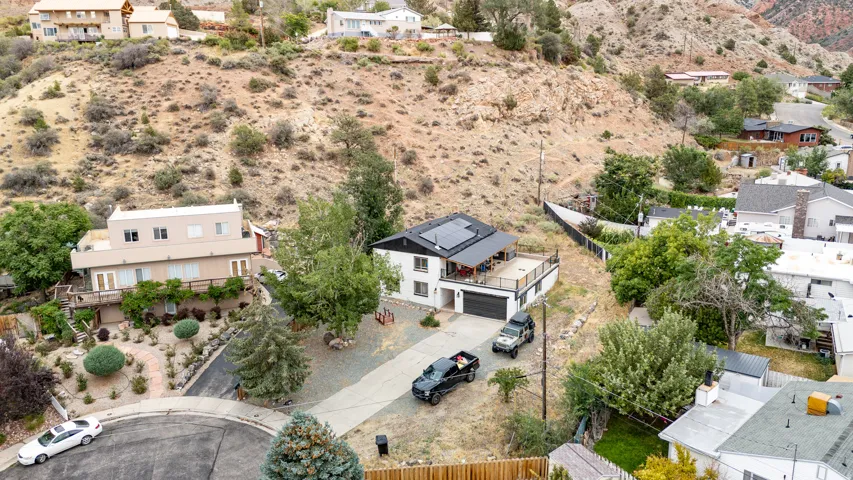 White exterior residence with a flat roof, elevated deck, and solar panel installation
