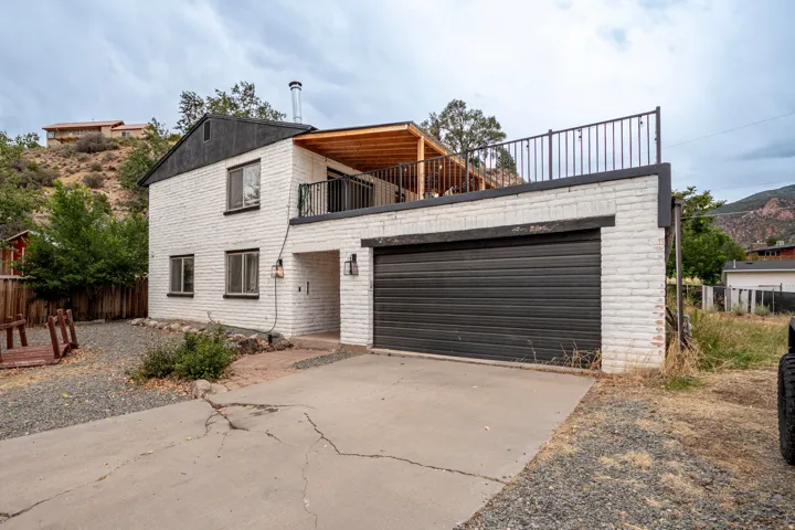 White brick exterior with a black garage door