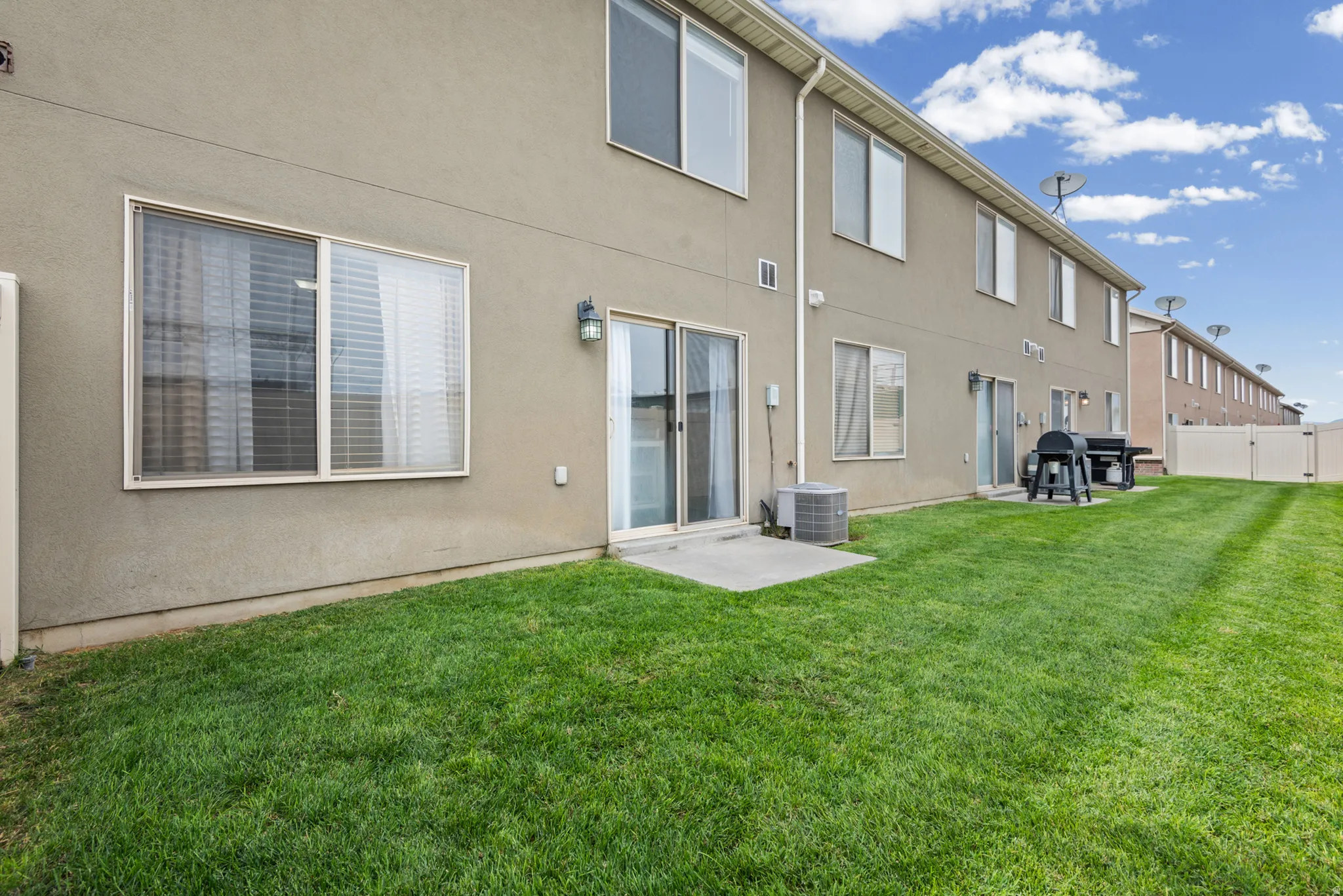 Expansive green lawn with a privacy fence