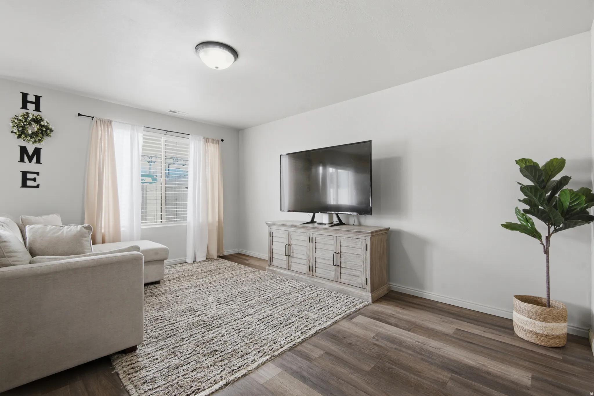 Wood-finish flooring with a neutral wall color, featuring a ceiling-mounted light fixture