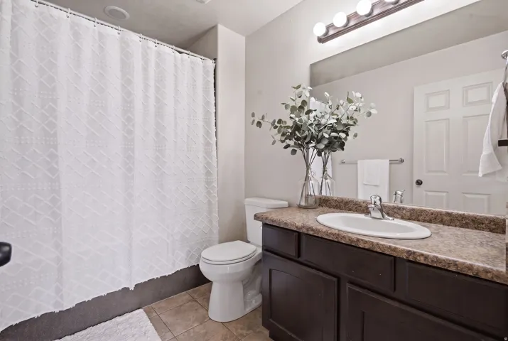 Single vanity with an integrated sink, dark wood-finish cabinetry, and a full-width mirror