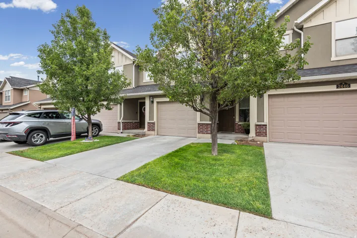 Tan stucco exterior with brick accents, attached garages, and concrete driveways