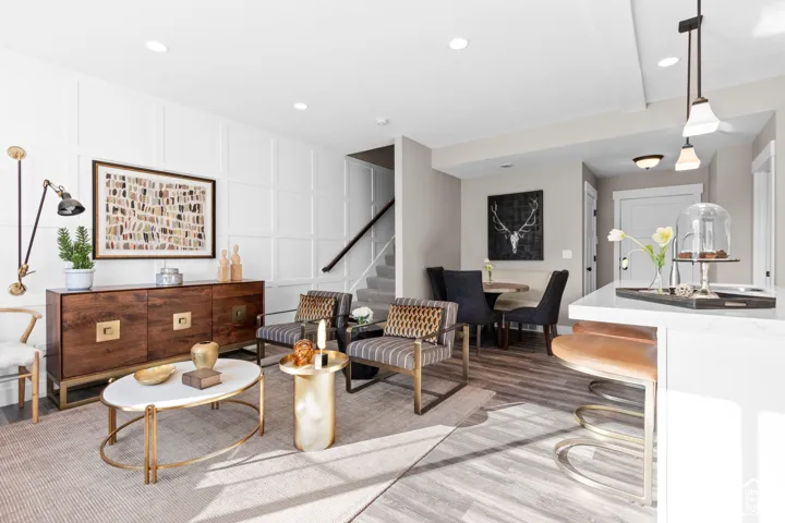 White paneled accent wall, wood-finish flooring, recessed lighting, and a built-in staircase