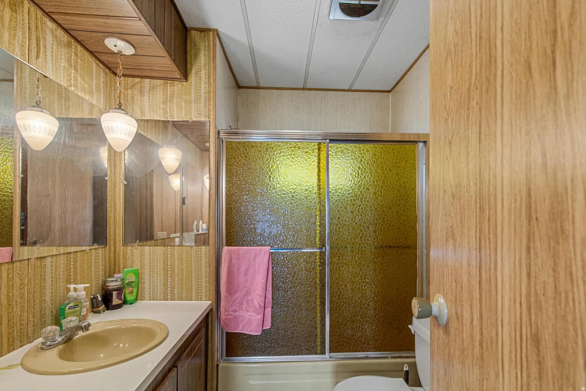 Bathroom with a shower-tub combination and sliding frosted glass doors