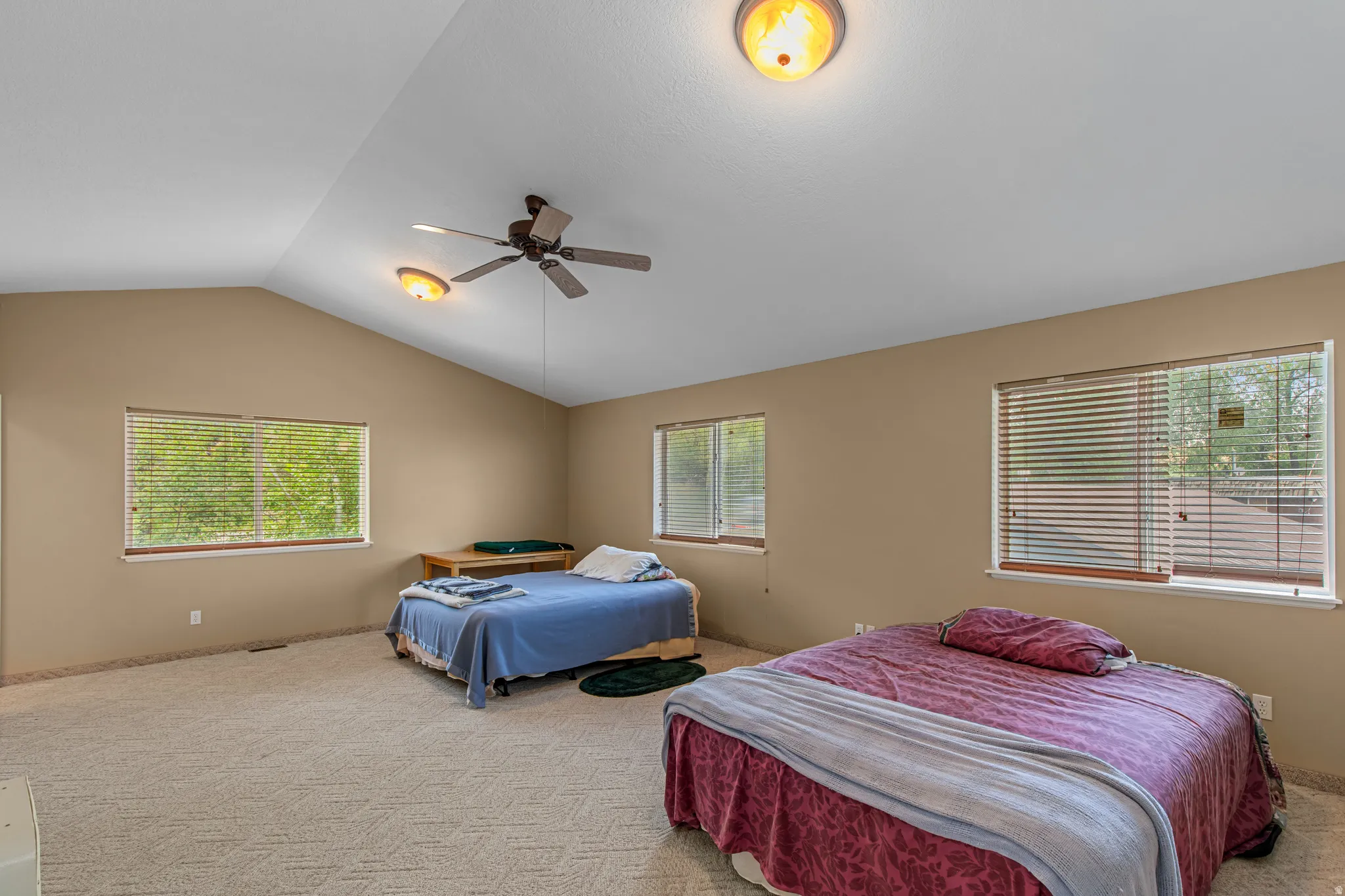 Vaulted ceiling with a ceiling fan, recessed lighting, and multiple windows with blinds