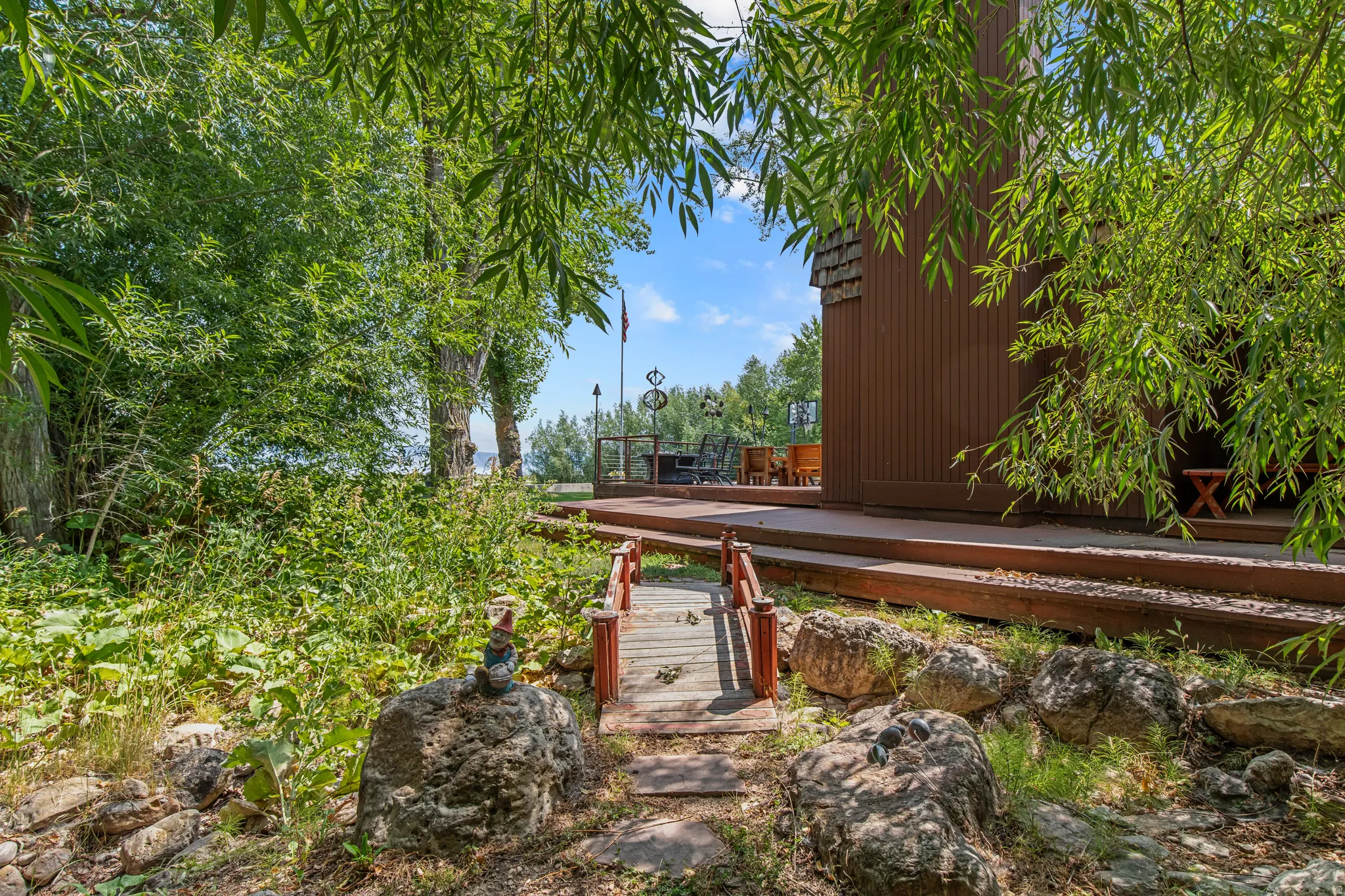 Wood siding exterior with a wood deck, wood bridge, and natural rock landscaping